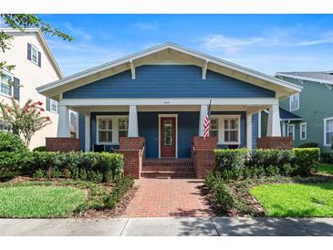 Charming blue home featuring a brick pathway leading to a cozy front porch with stately columns at 4310 Ethan Lane Ln, Orlando, FL 32814
