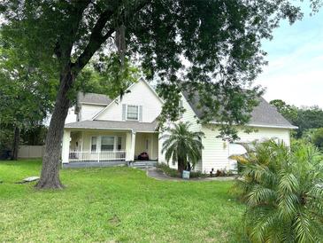 Charming two-story home with a covered front porch and mature trees in a spacious yard at 6230 Cranberry Dr, Port Orange, FL 32127