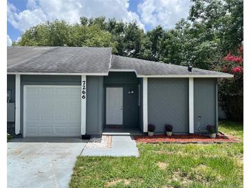 Charming single-story home with a well-maintained lawn and a garage, offering an inviting curb appeal at 7266 Oak Meadows Cir, Orlando, FL 32835