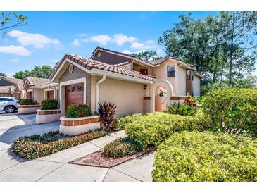 Charming two-story home with a tile roof, manicured landscaping, and an attached garage at 7742 Sugar Bend Dr # 7742, Orlando, FL 32819