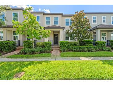 Well-maintained townhouse featuring a landscaped front yard and a welcoming entrance at 9591 Amber Chestnut Way, Winter Garden, FL 34787