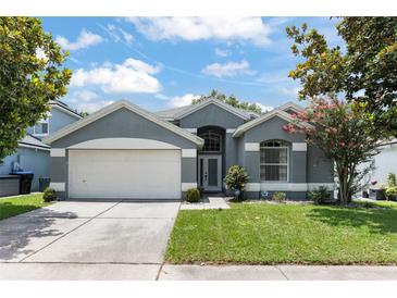 Charming single-story home with a two-car garage, neutral paint, and well-manicured lawn at 10064 River Glen Ct, Orlando, FL 32825