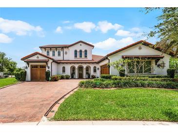 Elegant two-story home with a beautiful brick driveway and well-maintained landscaping at 10630 Mobberley Cir, Orlando, FL 32832