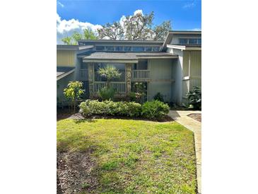 Inviting home featuring a quaint front garden, stone accents, and a second-story balcony at 116 Palm View Ct # 3535/6, Haines City, FL 33844