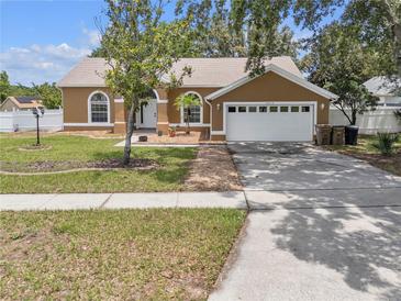 Charming one-story home featuring a two-car garage, manicured lawn, and welcoming curb appeal at 12713 Pine Arbor Dr, Clermont, FL 34711