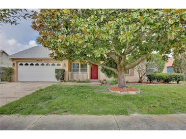 Charming single-story home featuring a red front door and a large tree providing shade in the front yard at 14063 Ithaca Way, Orlando, FL 32826