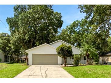 Charming single-story home with a two-car garage and a well-manicured lawn at 142 E 9Th St, Chuluota, FL 32766