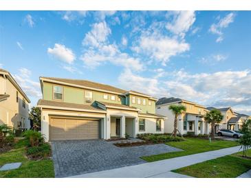 Beautiful two-story home with a two car garage and a landscaped front yard under a partly cloudy sky at 2537 Shanti Dr, Kissimmee, FL 34746