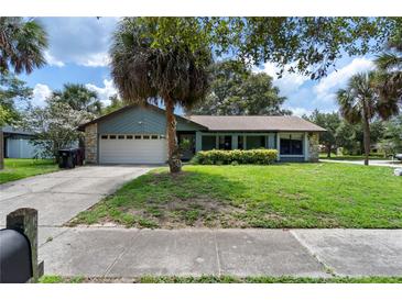 Charming home with a well-manicured lawn, mature landscaping, and a two-car garage at 3220 Cardigan Ct, Orlando, FL 32812