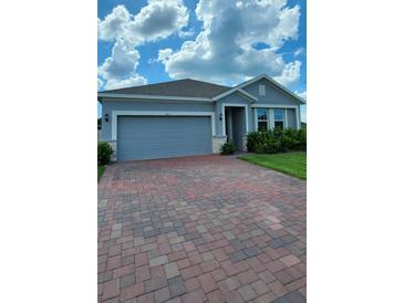 Charming single-story home featuring a paved driveway and attached two-car garage at 483 Shadow Gorge Way, Eustis, FL 32736