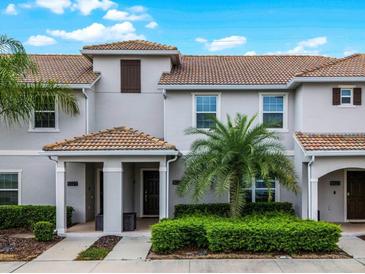 Charming townhome with a tile roof, covered porch, and beautifully maintained landscaping at 5025 Windermere Ave, Kissimmee, FL 34746