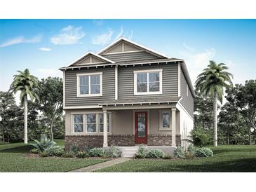 Charming two-story home with a brick foundation, gray siding, red door, and tropical landscaping at 532 Green Tracker Ave, Clermont, FL 34715