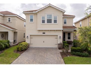 Charming two-story home with a well-manicured lawn and a two-car garage at 1097 Trappers Trail Loop, Davenport, FL 33896