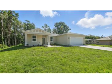 Charming single-story home featuring a spacious front yard and two-car garage at 17 Cypress Run, Haines City, FL 33844