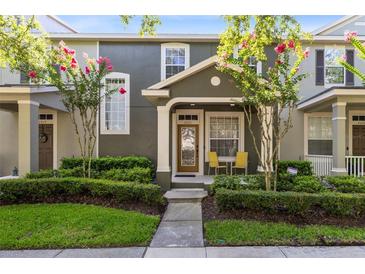 Charming townhome featuring a cozy porch, mature trees, and well-manicured landscaping at 2021 Sweet Birch Ln, Orlando, FL 32828