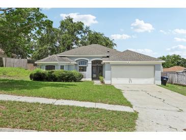 Charming single-story home with a well-manicured lawn, mature landscaping, and attached two-car garage at 3326 Sassaquin Ct, Orlando, FL 32818