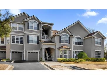 Exterior view of a condominium building with gray siding and arched windows at 3379 S Kirkman Rd # 1027, Orlando, FL 32811