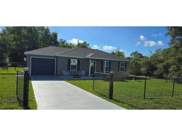 Charming single-story home featuring a well-maintained lawn and a cozy front porch at 35 Olive Cir, Ocala, FL 34472