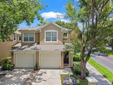 Charming two-story townhome featuring a two-car garage, well-maintained landscaping, and a welcoming entryway at 6453 Alcalde Ct # 110, Orlando, FL 32835
