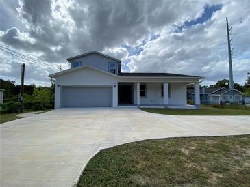 New two-story home featuring modern design, a spacious driveway, and an attached two-car garage at 9122 Trevarthon Rd, Orlando, FL 32817