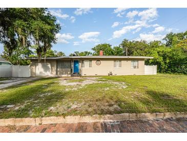 Charming single-story home with an attached garage and quaint landscaping in a residential neighborhood at 131 N Central Ave, Apopka, FL 32703