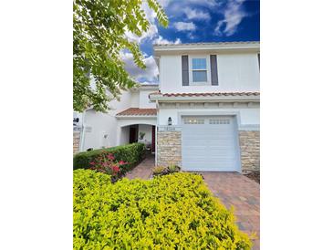 Charming townhome with a one-car garage, colorful landscaping, and a welcoming red tile roof at 14164 Swanley St, Orlando, FL 32832