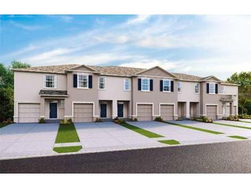 New townhome exteriors with attached garages, enhanced by landscaping and contemporary design features at 200 Feltrim Reserve Blvd, Davenport, FL 33837