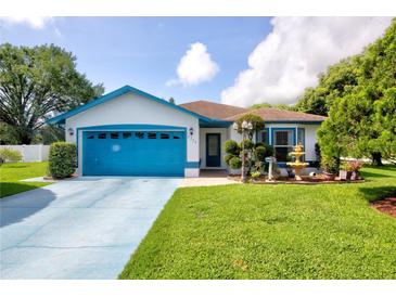 Charming single-story home with a well-maintained lawn, blue trim, and a blue driveway for added curb appeal at 2334 W Doris St, Kissimmee, FL 34741