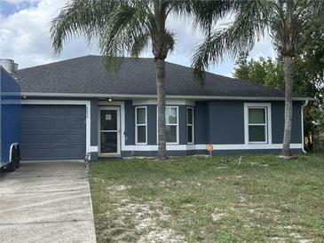 Charming single-story home with a gray exterior, front yard, and two palm trees at 2830 Gramercy Dr, Deltona, FL 32738