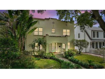 Charming home exterior with lush tropical landscaping and a beautiful brick walkway leading to the front door at 501 Richmond St, Orlando, FL 32806