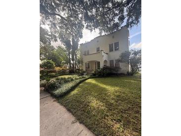 Stunning two-story home featuring lush landscaping and a well-manicured lawn, nestled under mature trees at 501 Richmond St, Orlando, FL 32806