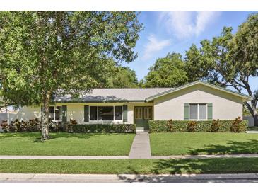 Charming single-story home featuring a well-manicured lawn and lush green landscaping at 5334 Cypress Dr, Winter Park, FL 32792