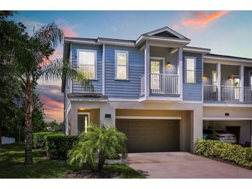 Charming two-story home with a blue exterior, balcony, and attached garage at 995 Grand Wildmere, Longwood, FL 32750