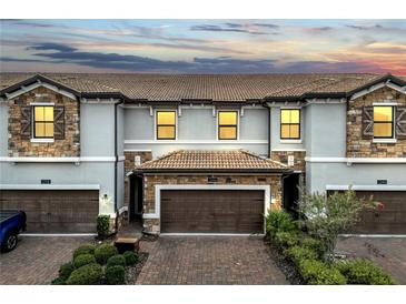 Beautiful two-story townhome features a brick-paved driveway and attached two-car garage at 1246 Payne Stewart Dr, Davenport, FL 33896