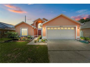 Charming single-Gathering home with a well-manicured lawn, colorful flowers, and an attached two-car garage at 1803 Tillstream Dr, Orlando, FL 32818