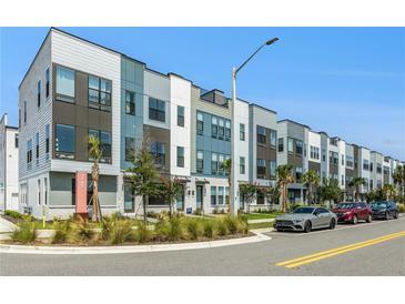 Modern townhome exteriors featuring contemporary designs, colorful accents, and landscaped surroundings at 2018 Packing District Way, Orlando, FL 32804
