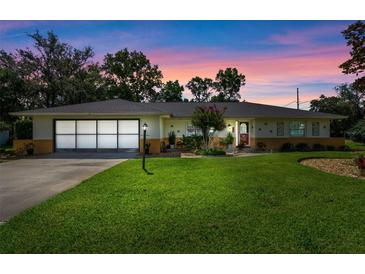 Charming single-story home with lush lawn, mature landscaping, and a two-car garage on a lovely lot at 73 Alano Rd, Debary, FL 32713