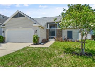 Charming single-Gathering home with an attached garage, front lawn, and beautiful landscaping at 10473 Glassborough Dr, Orlando, FL 32825