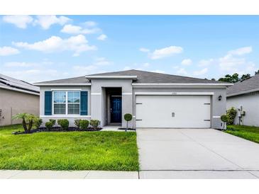 Charming single Gathering home featuring a well-manicured lawn and a classic two-car garage at 1351 Fox Squirrel Dr, Davenport, FL 33897
