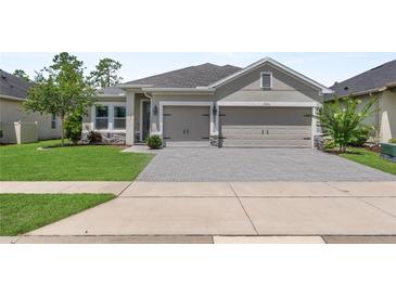 Charming single-story home featuring a two-car garage, well-maintained lawn, and inviting curb appeal at 17676 Passionflower Cir, Clermont, FL 34714