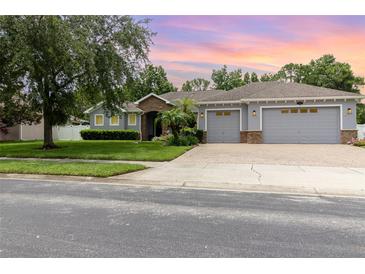 Charming single-Gathering home featuring a well-manicured lawn and a three car garage at 2588 Gabrielle Woods Pl, Oviedo, FL 32765