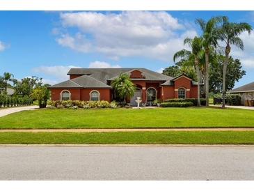 Charming one-story home with well-manicured lawn, mature palm trees, and vibrant landscaping at 5306 Crane Hill Ct, St Cloud, FL 34771