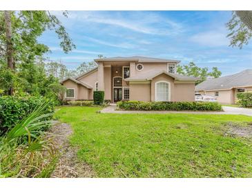Charming two-story home featuring manicured landscaping, a grand entrance, and an inviting front yard at 9285 Wickham Way, Orlando, FL 32836