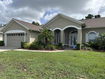 Charming single-story home featuring a well-manicured lawn and inviting front entrance with classic architectural details at 13000 Sandy Pine Ln, Clermont, FL 34711