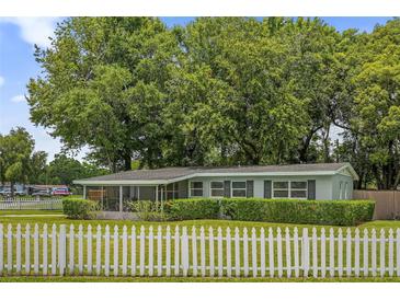 Charming single-story home with a white picket fence and well-manicured landscaping at 224 Woodmere Blvd, Sanford, FL 32773
