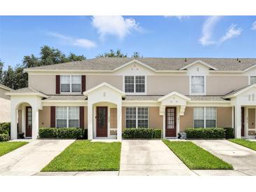 Inviting townhome featuring a well-manicured lawn and charming architectural details at 2409 Silver Palm Dr, Kissimmee, FL 34747