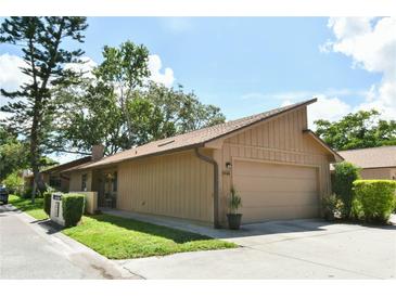Charming single-story home featuring an attached garage and a well-maintained lawn and landscaping at 271 Raintree Dr, Casselberry, FL 32707