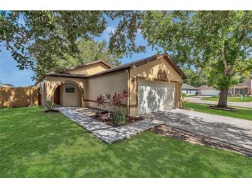 Charming single-Gathering home with lush front lawn, mature trees, and two car garage at 2935 Canoe Cir, St Cloud, FL 34772
