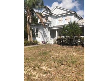 Charming two-story home with manicured landscaping and a welcoming front porch at 310 W Lake Ave, Auburndale, FL 33823