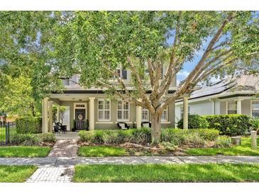 Charming two-story home featuring a covered front porch and lush landscaping at 513 Legacy Park Dr, Casselberry, FL 32707